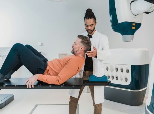 Radiology Tech helping patient lay down